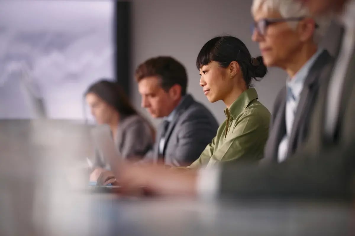 Japanese female entrepreneur working on a computer among her colleagues on a meeting in the office.